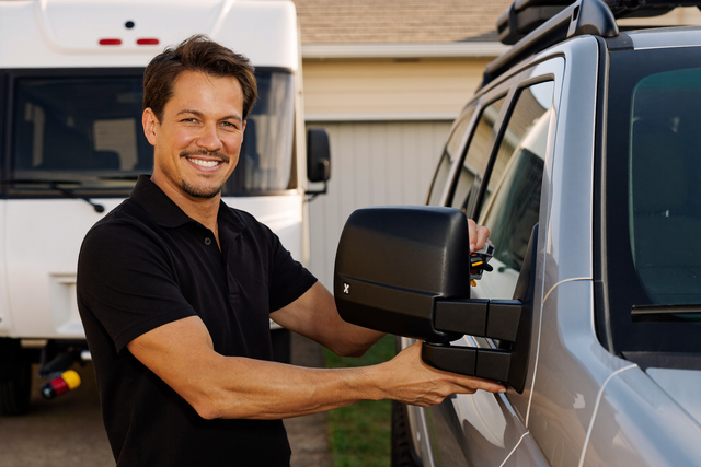 Technician fitting towing mirrors to a 4WD towing a caravan